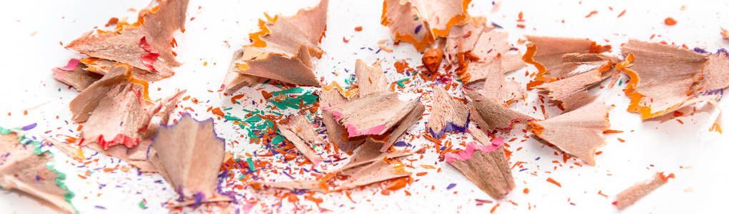 Shavings from colored pencils on white background. Art abstract background.